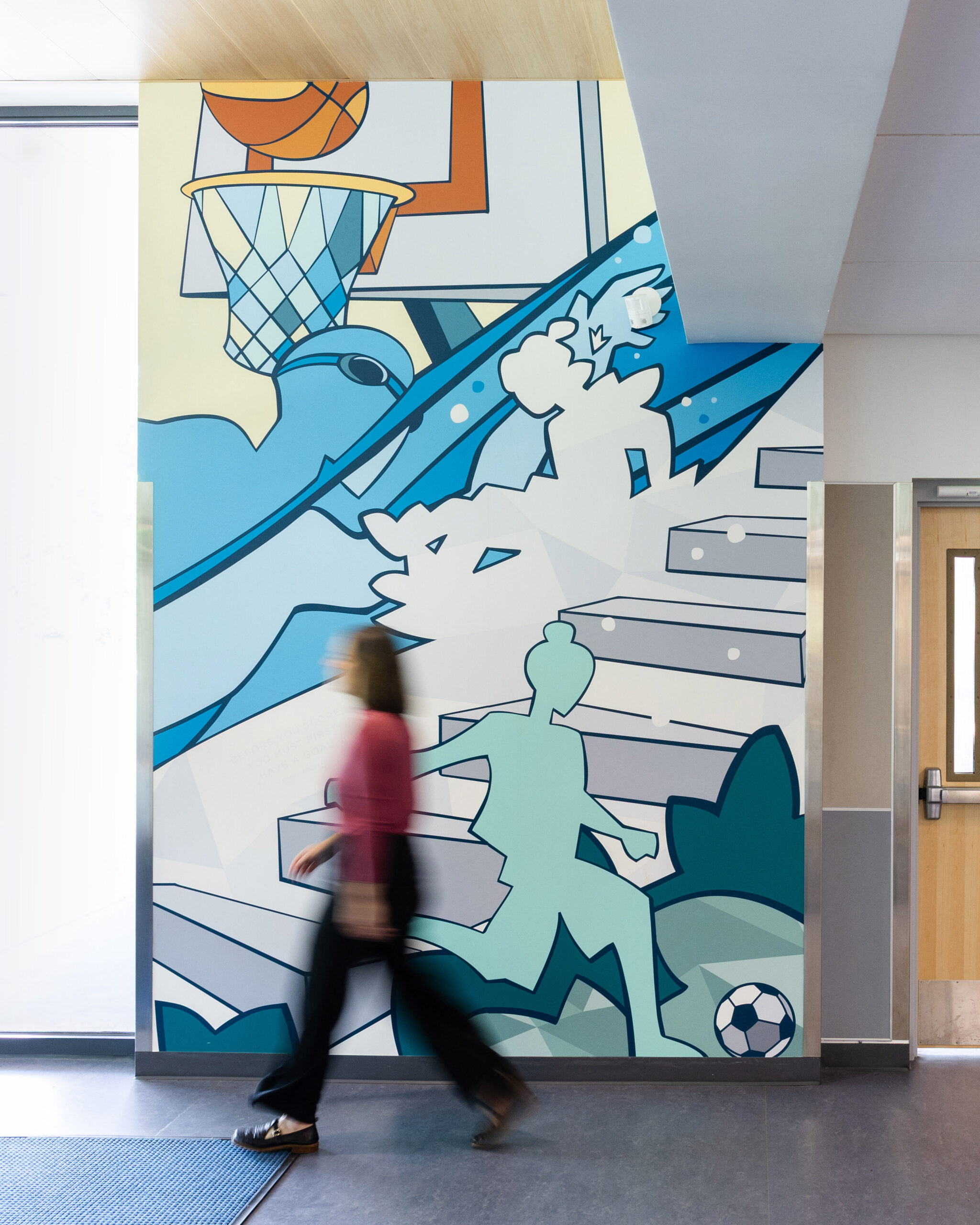 A woman walks by a wall mural at Charlottesville Middle School