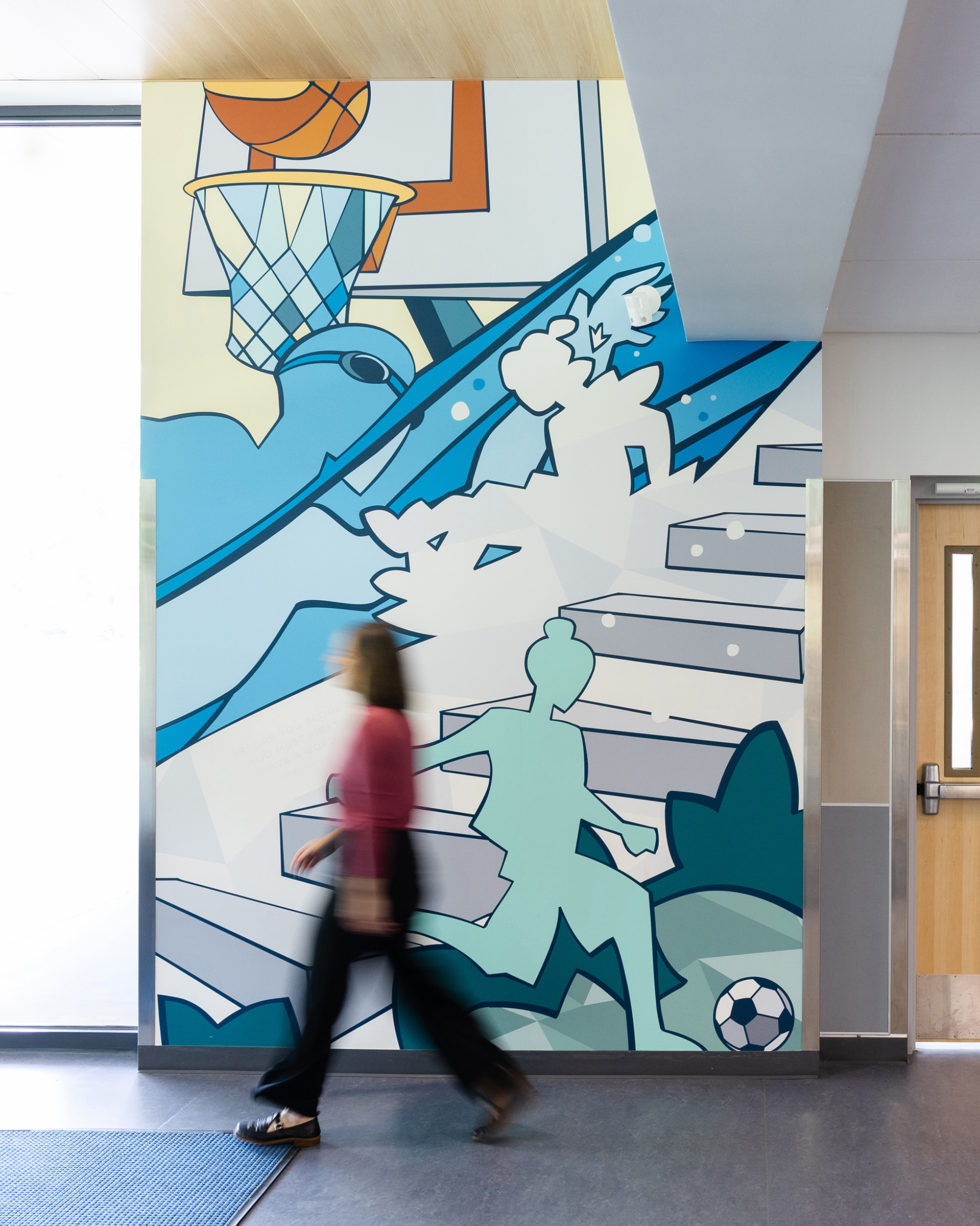 A woman walks by a wall mural at Charlottesville Middle School