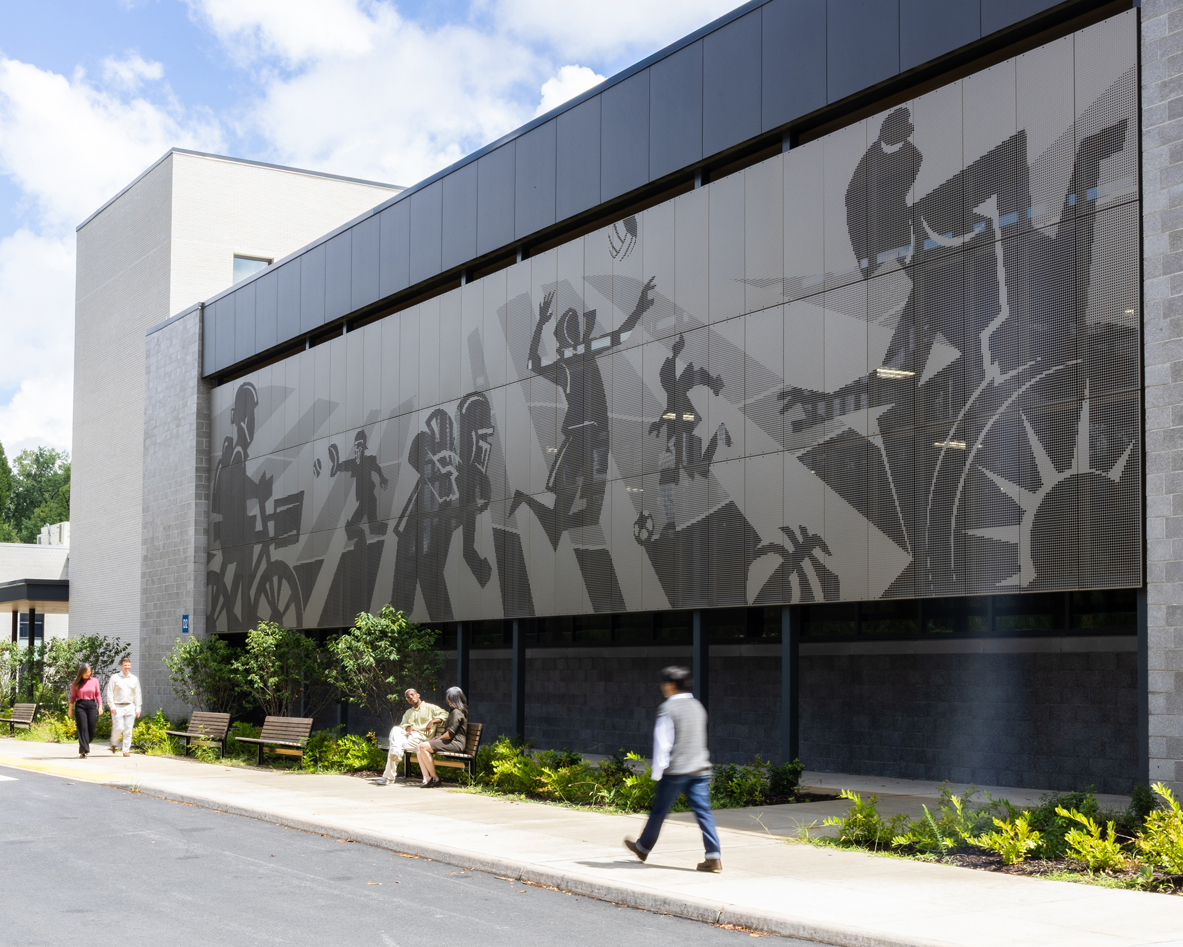 Exterior shot of Charlottesville Middle School wall graphics with people walking by