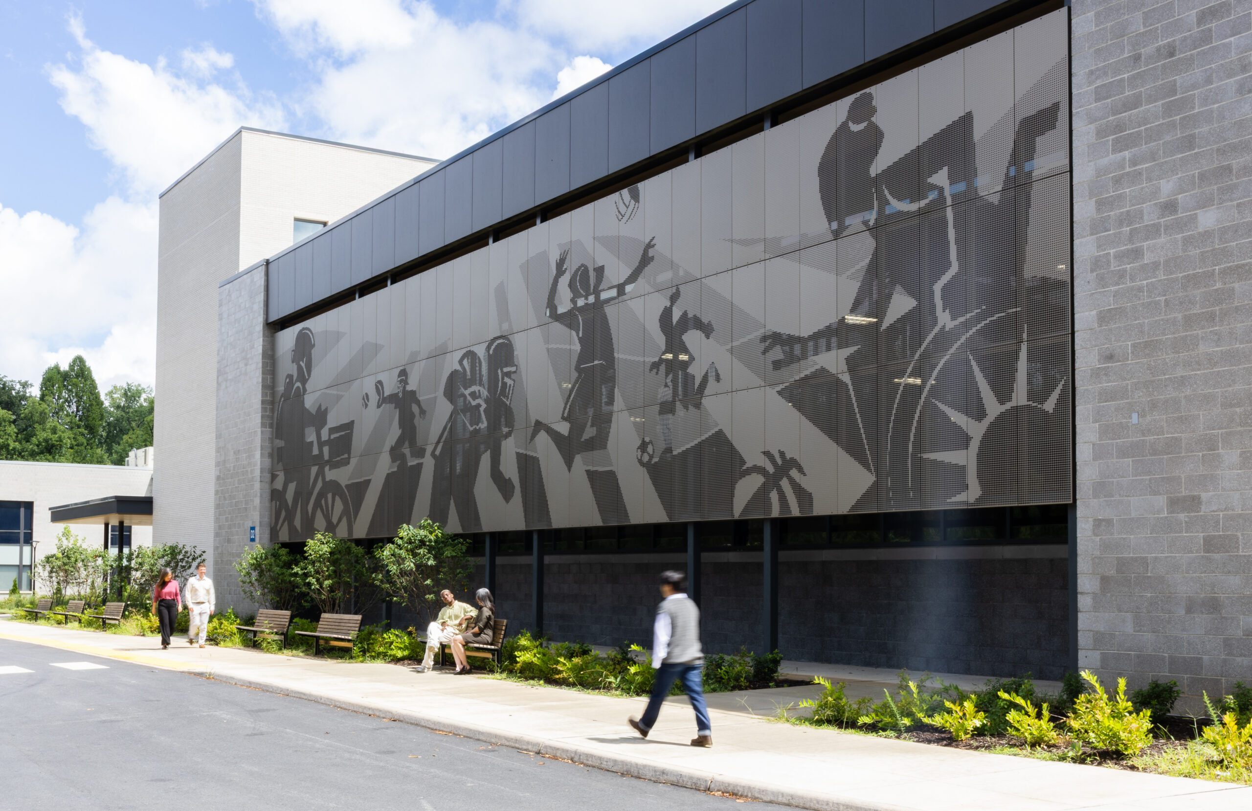 Exterior shot of Charlottesville Middle School wall graphics with people walking by