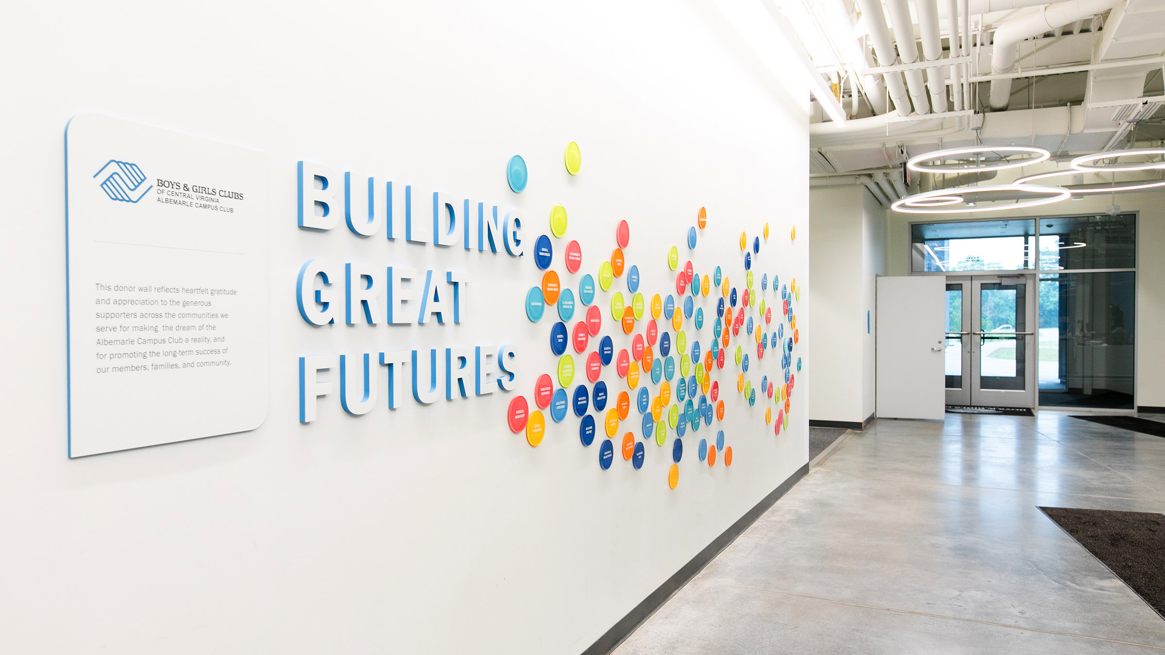 Colorful donor signage on a wall at the Boys & Girls Club’s Albemarle Campus with text that says "Building great futures".