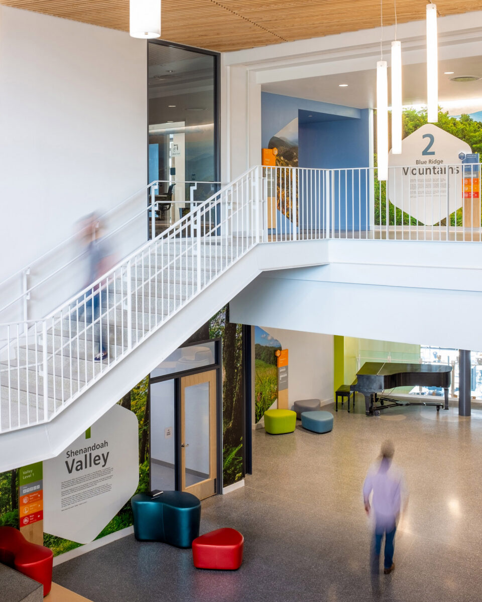 People using the stairs at Bluestone Elementary School with wall graphics behind them