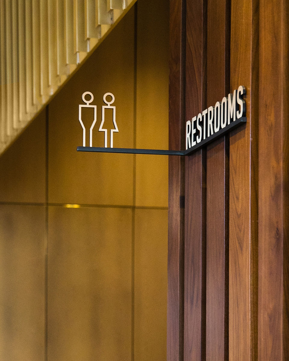 Overhead restroom signs at CODE