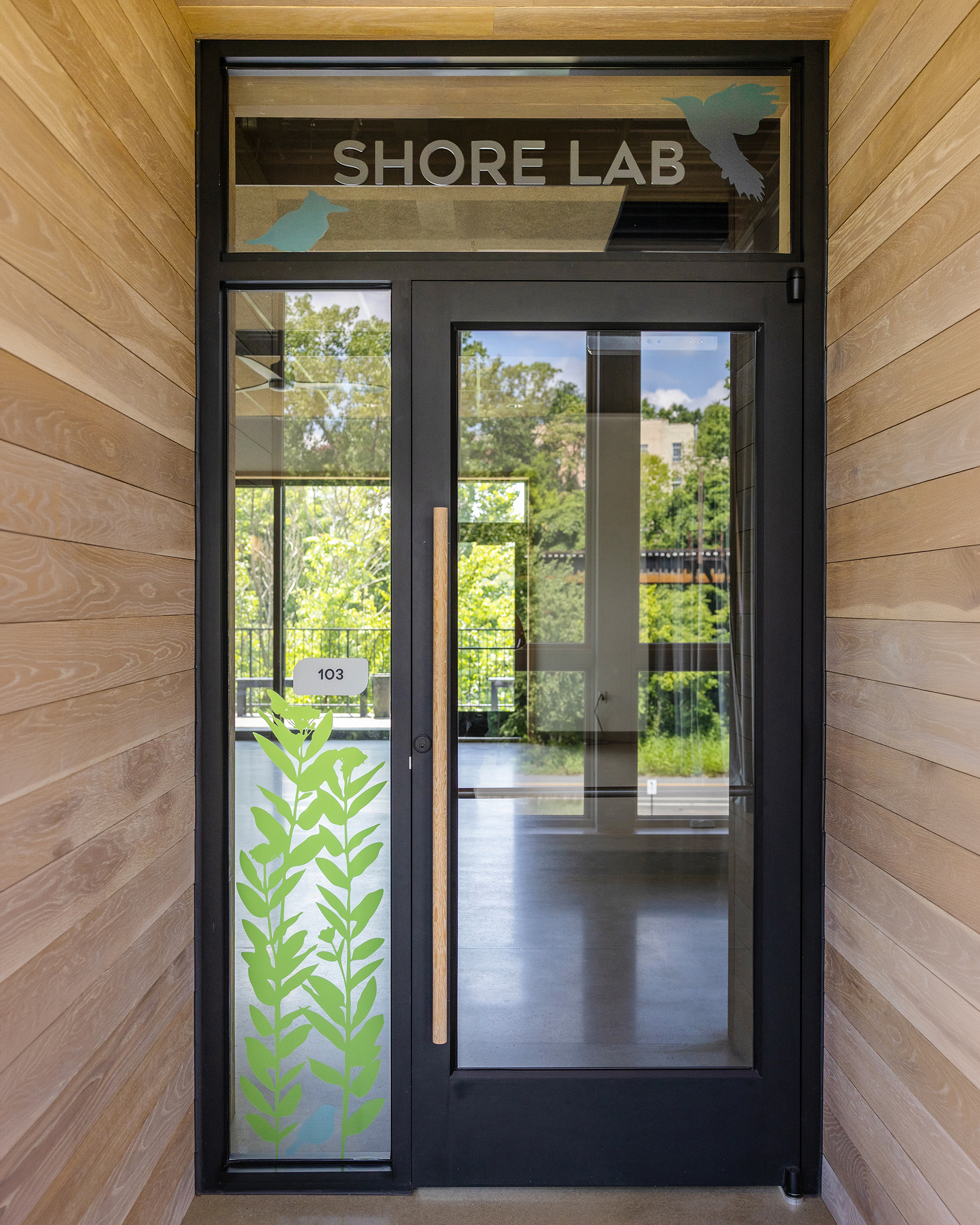 Entry door at JRA Buzzard River Education Center with glass graphics and "Shore Lab" text above the door.