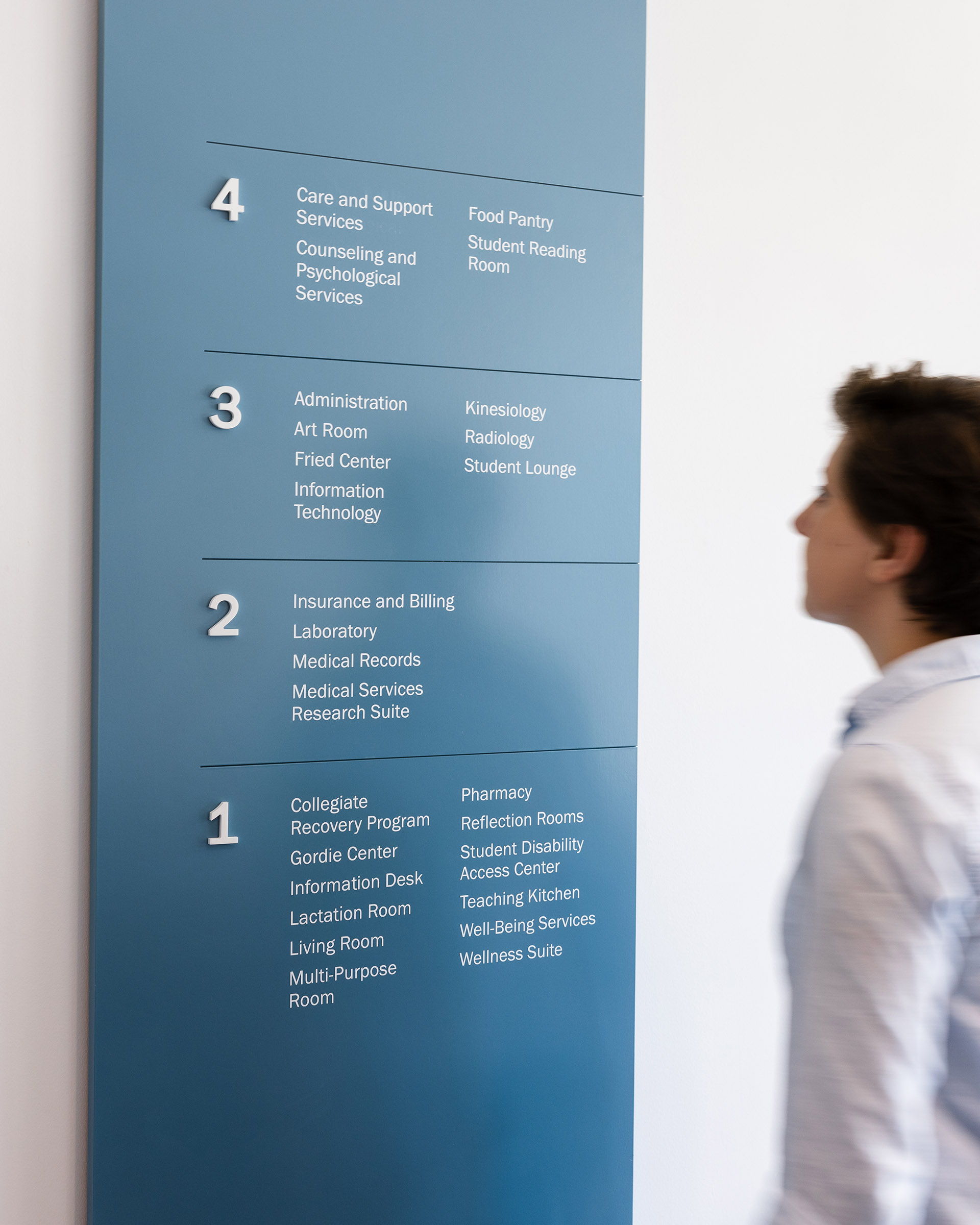 A woman using a directory at Student Health & Wellness Center