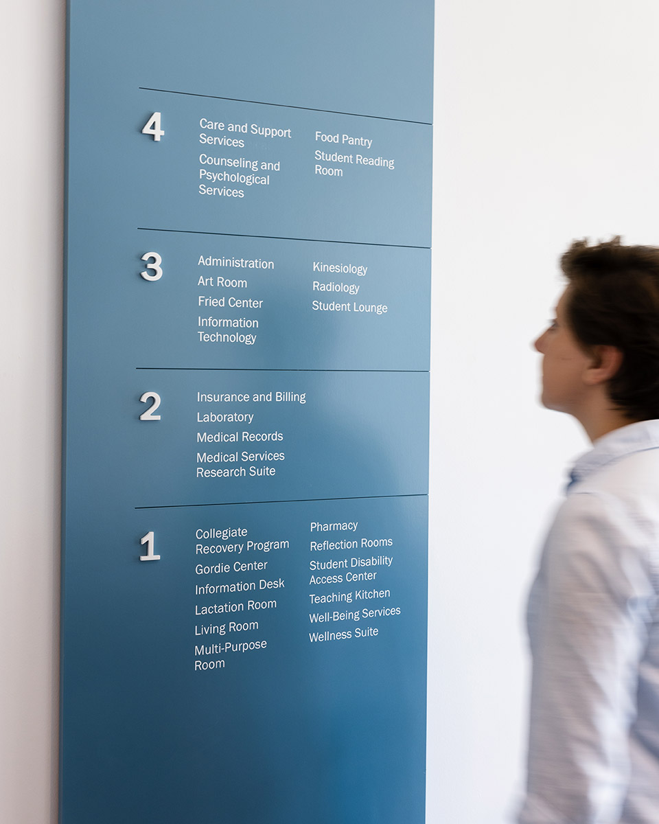 A woman using a directory at Student Health & Wellness Center