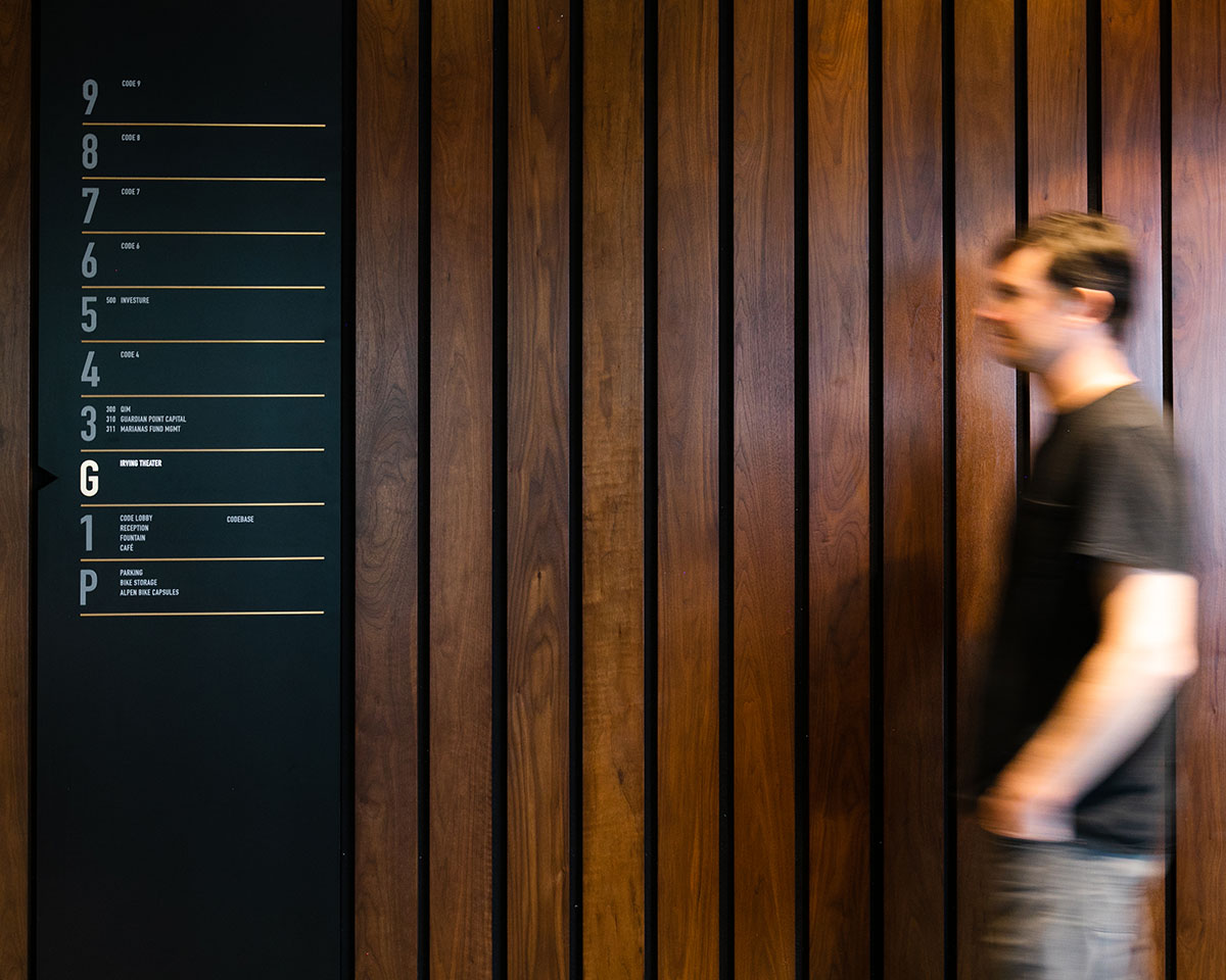 A man walks toward a directional sign at CODE