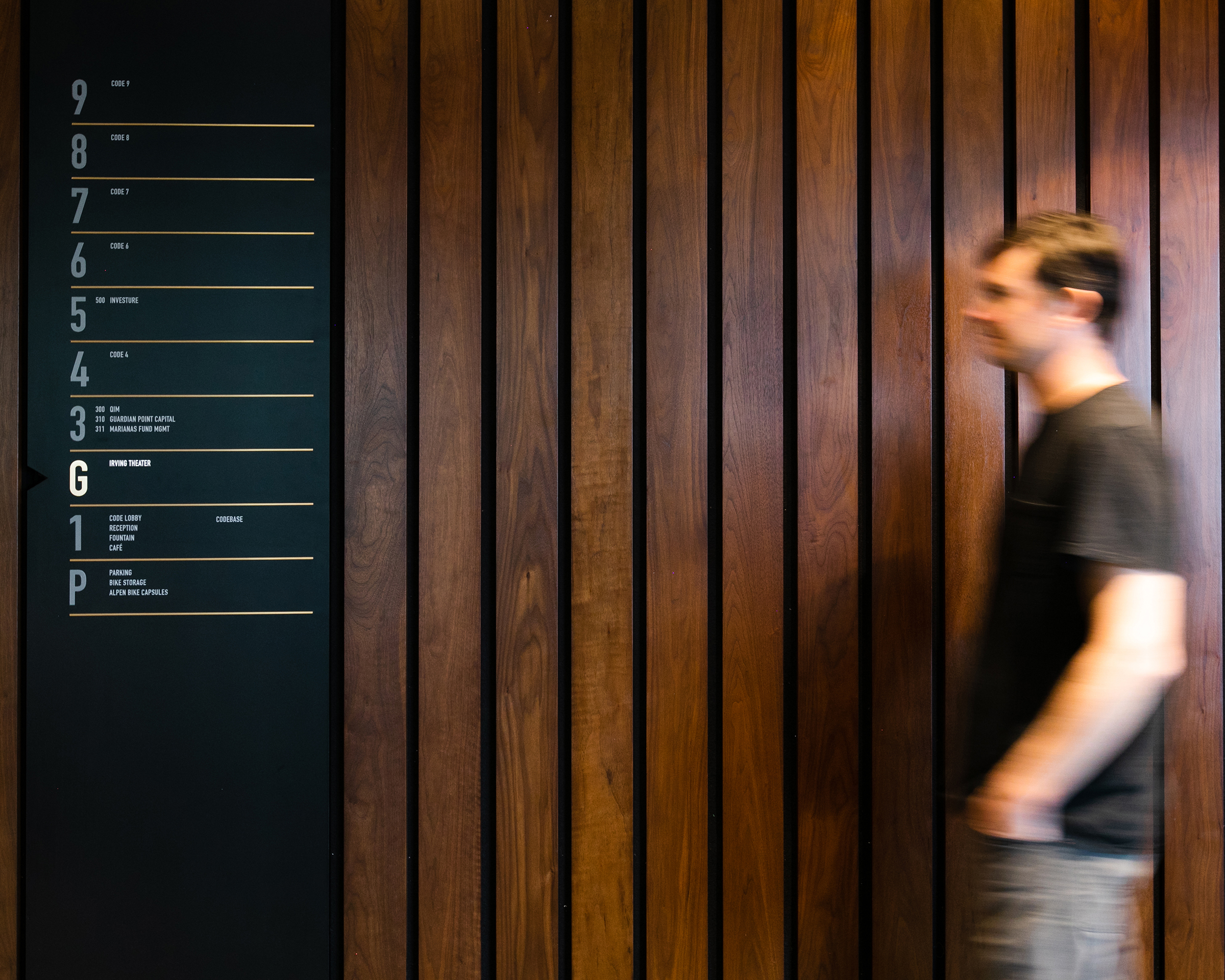 A man walks toward a directional sign at CODE