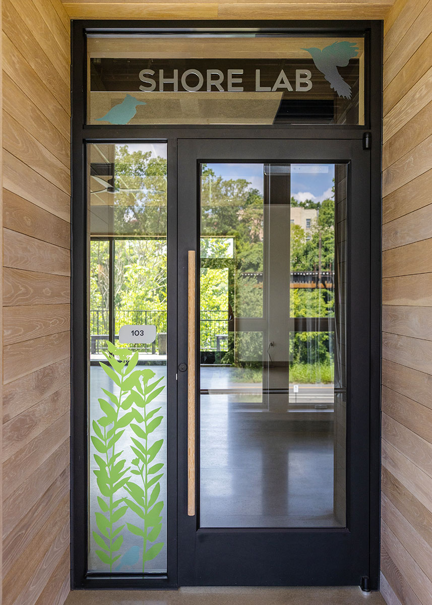 Entry door at JRA Buzzard River Education Center with glass graphics and "Shore Lab" text above the door.