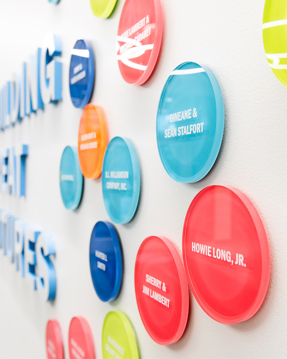 Angled view of colorful, round donor signage on a wall at the Boys & Girls Club’s Albemarle Campus