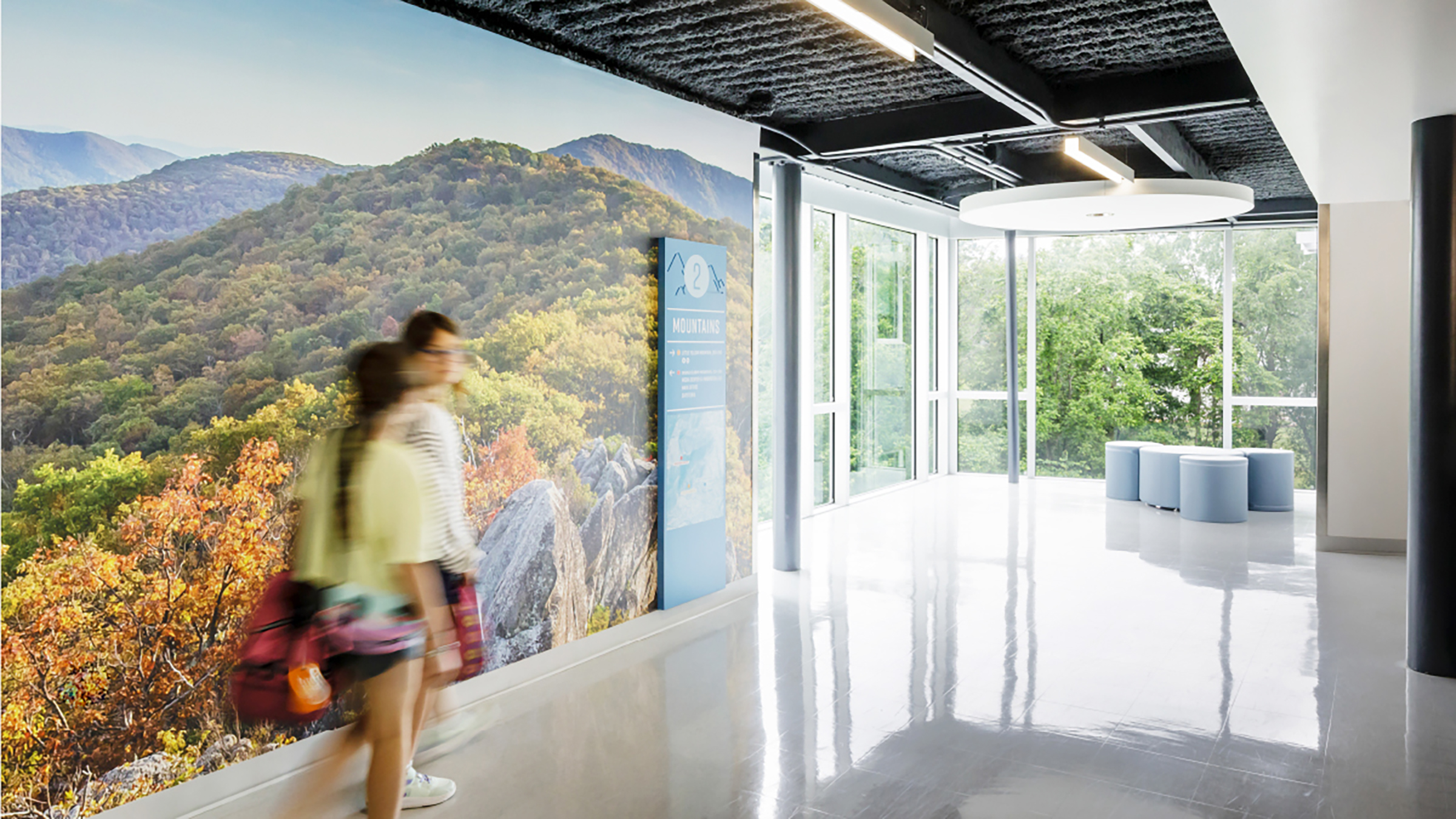 People walking by wall graphics of the blue ridge mountains at Crozet Elementary School